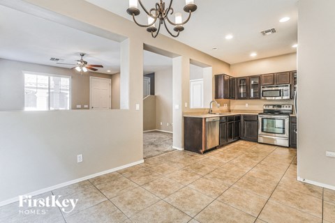 A kitchen with a tile floor and a chandelier.