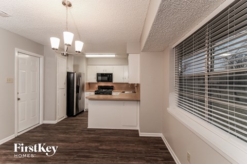 A kitchen area with a refrigerator, microwave, and a counter with a wooden top.