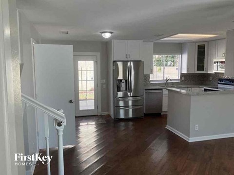 a kitchen with a stainless steel refrigerator and a staircase