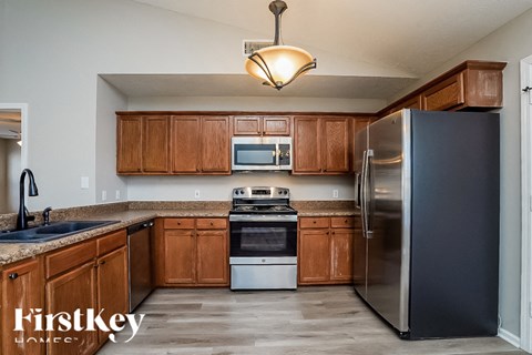 A kitchen with wooden cabinets and a stainless steel refrigerator.