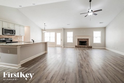A spacious living room with wood flooring and a fireplace.
