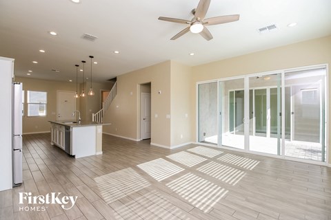 a large living room with a kitchen and a ceiling fan