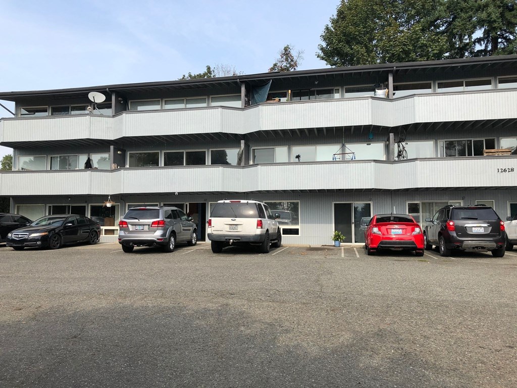 a large white building with cars parked in front of it