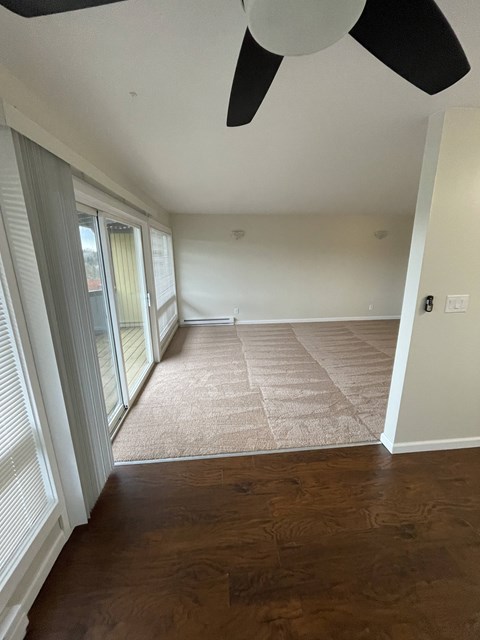 an empty living room with a rug and a window