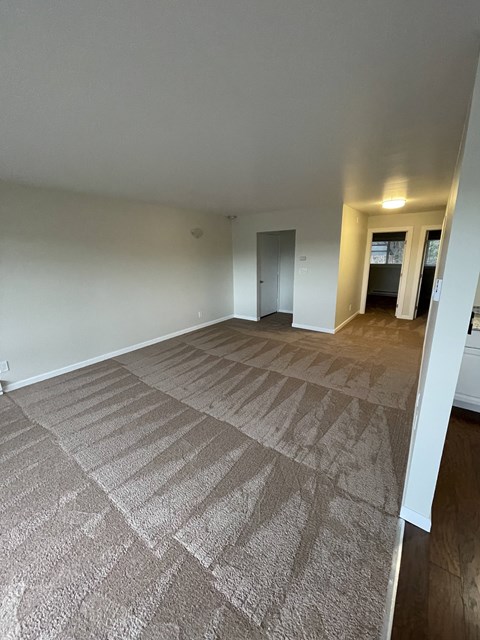 a living room and dining room with a carpeted floor
