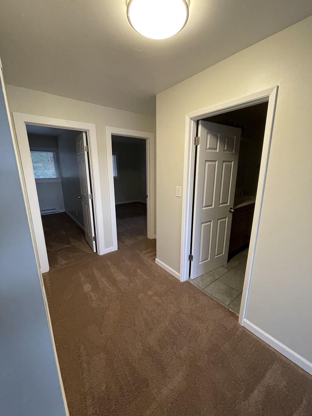 a look down the hallway of an empty house with a door open