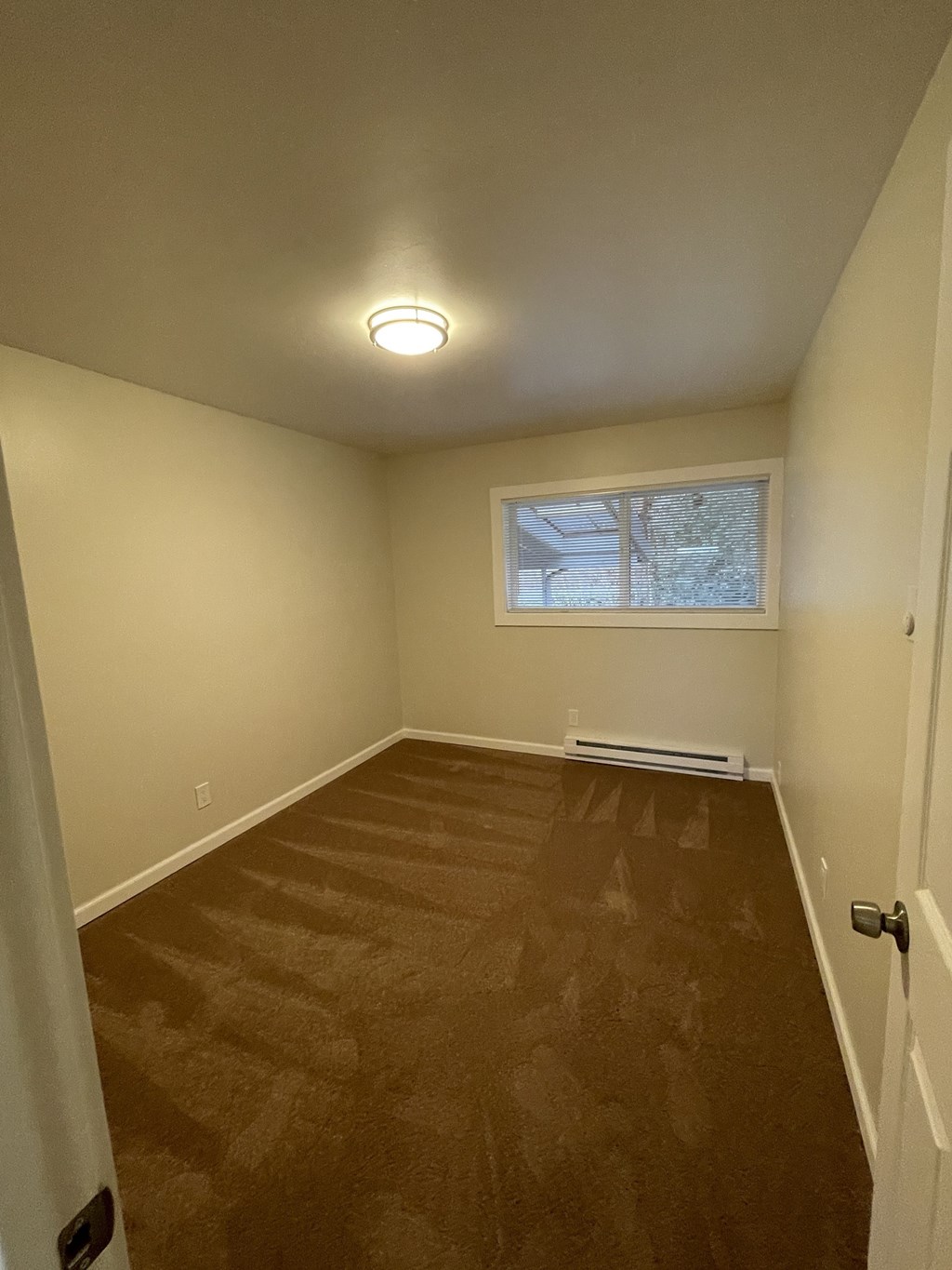 a empty room with a window and wooden floors