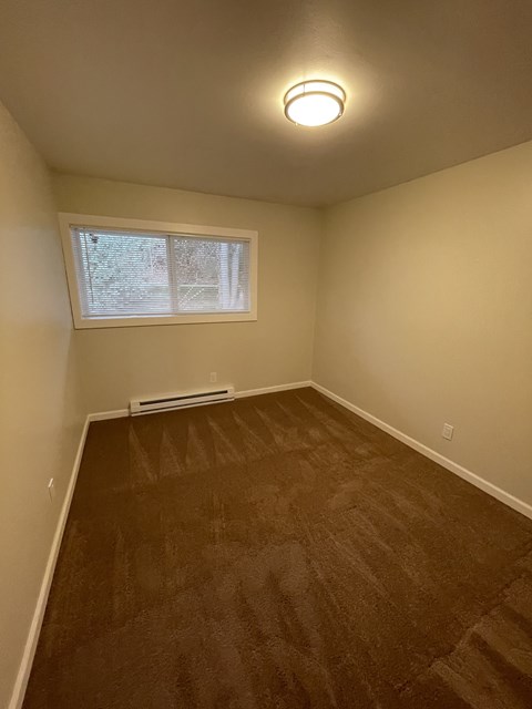 a empty room with wooden floors and a window