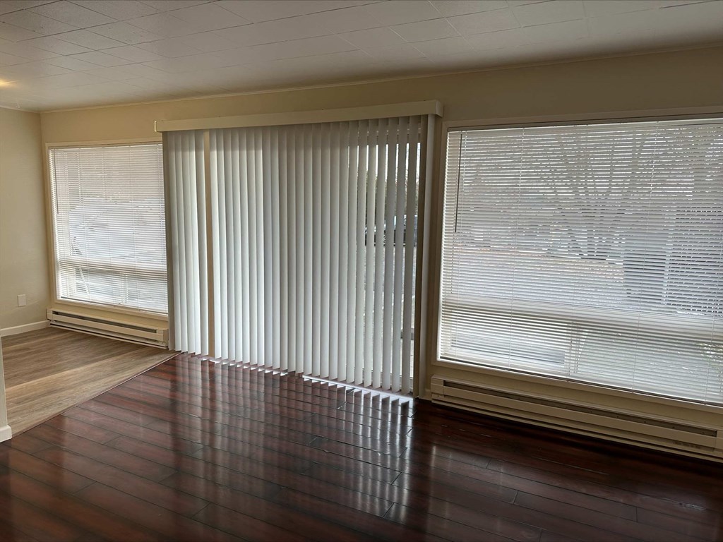 an empty living room with blinds on the window