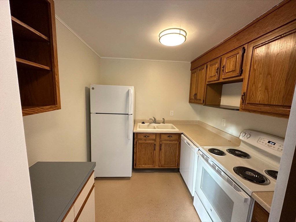 a kitchen with white appliances and wooden cabinets