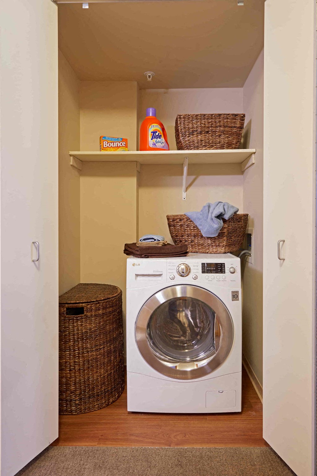 A laundry room with a washing machine and a basket on top of it.