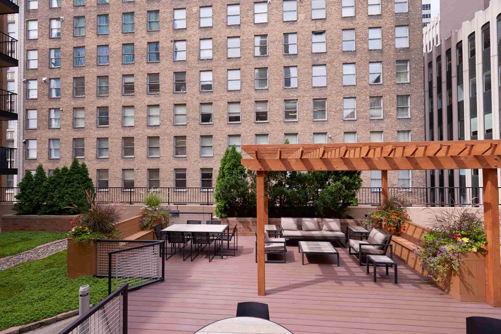 A patio with a table and chairs with a building in the background.