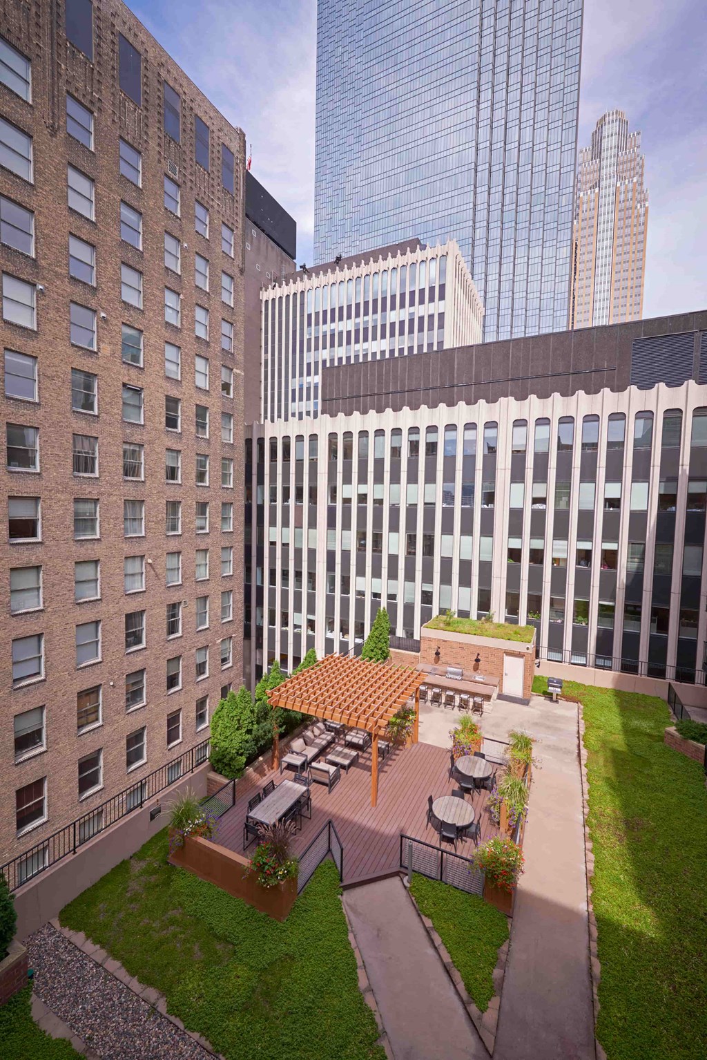 A modern building with a courtyard and a patio with a table and chairs.