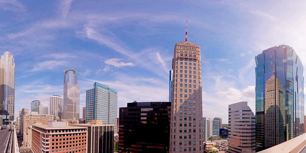 A cityscape with a variety of buildings, including a tall one with a pointed top.
