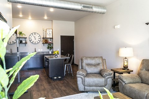 A living room with a grey couch, a grey chair and a grey armchair.