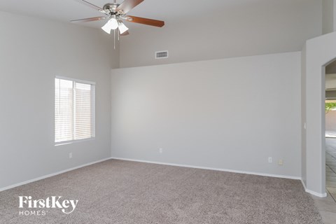 a bedroom with a ceiling fan and a carpeted floor