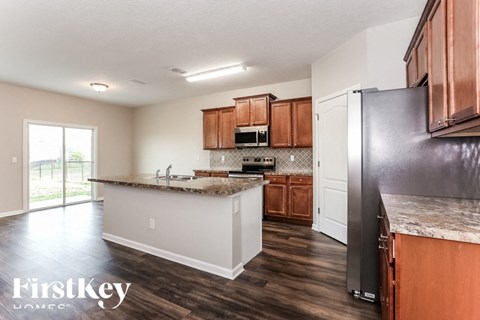 A kitchen with wooden cabinets and a black refrigerator.