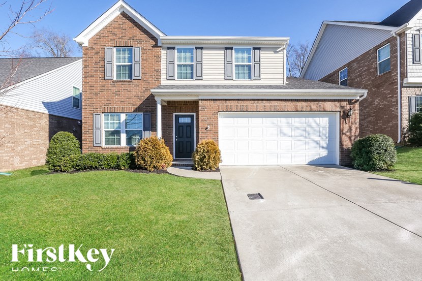 A house with a garage and a driveway in front of it.