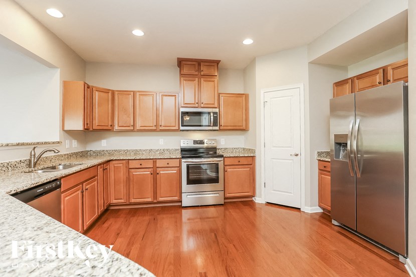 A kitchen with wooden cabinets and a stainless steel refrigerator.