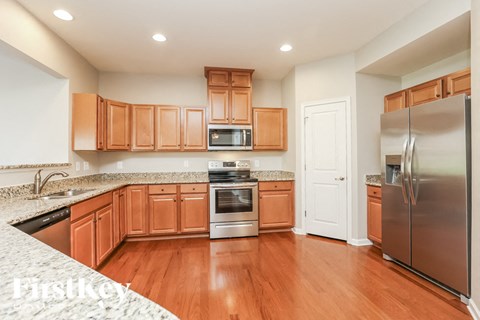 A kitchen with wooden cabinets and a stainless steel refrigerator.