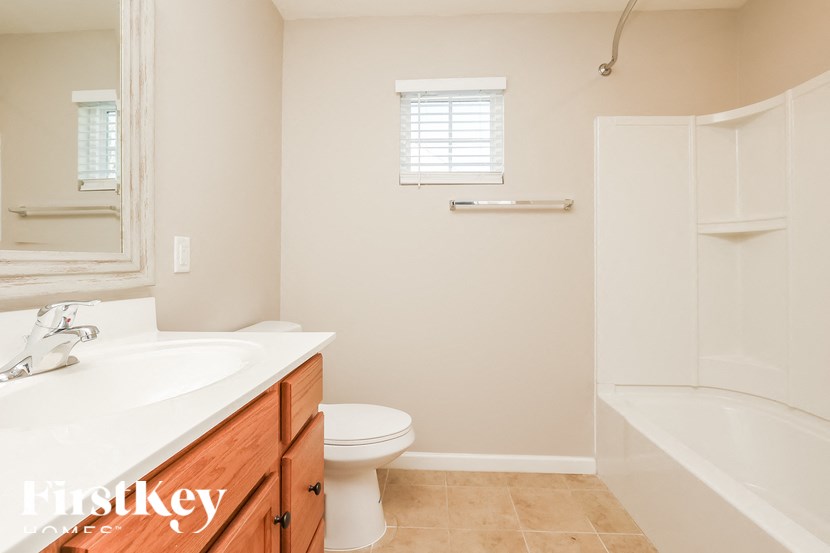 A white bathroom with a toilet, sink, and bathtub.