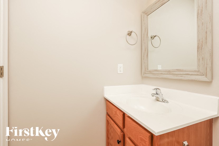 A bathroom with a white sink and a mirror above it.