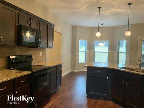 an empty kitchen with black cabinets and a microwave