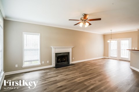 A spacious room with a fireplace and a ceiling fan.