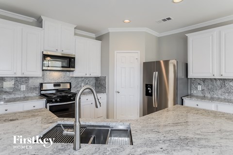 A kitchen with a stainless steel refrigerator and a sink.