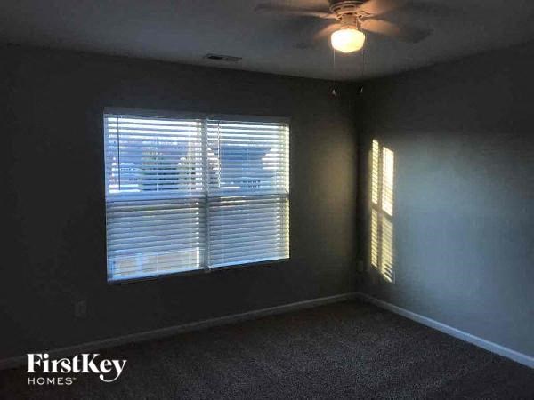 an empty room with a window and a ceiling fan