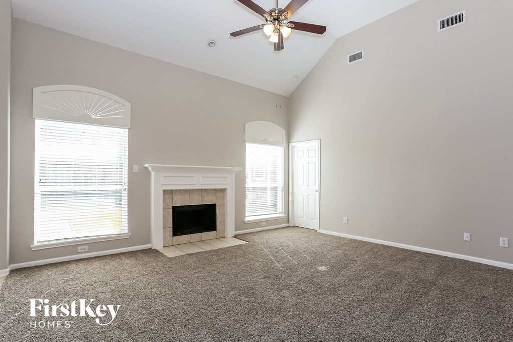 a living room with a fireplace and a ceiling fan