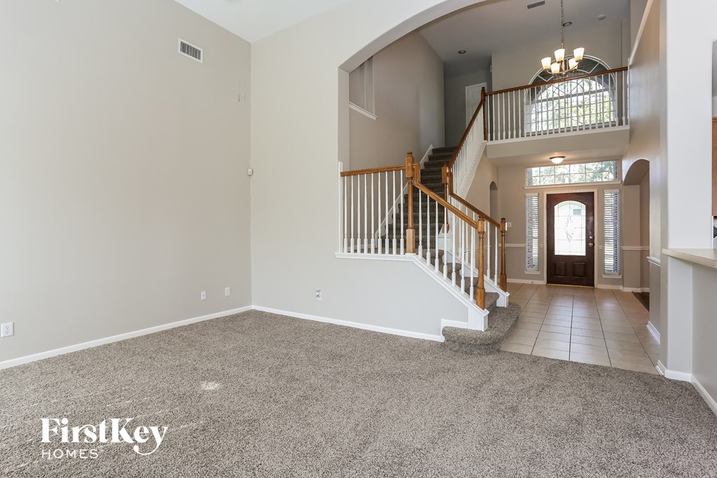 the foyer and entryway of a house with carpeted floors and a staircase