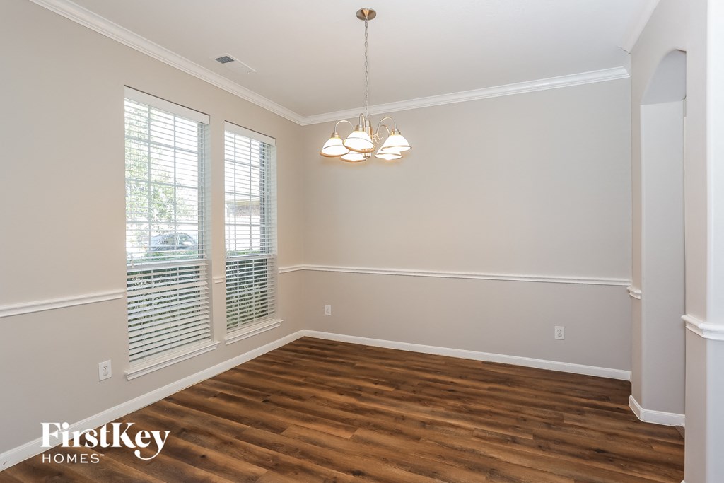 the spacious dining room with hardwood flooring and a chandelier