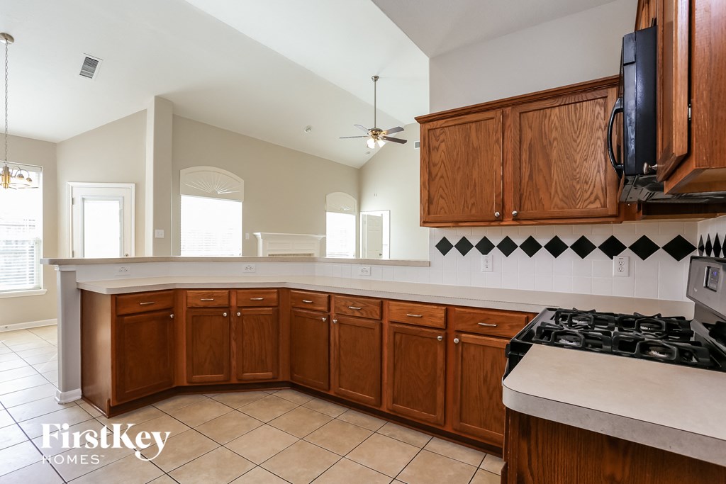 a kitchen with wooden cabinets and a white counter top
