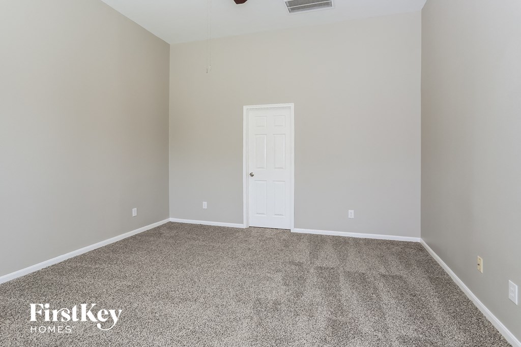 a empty room with carpet and a white door
