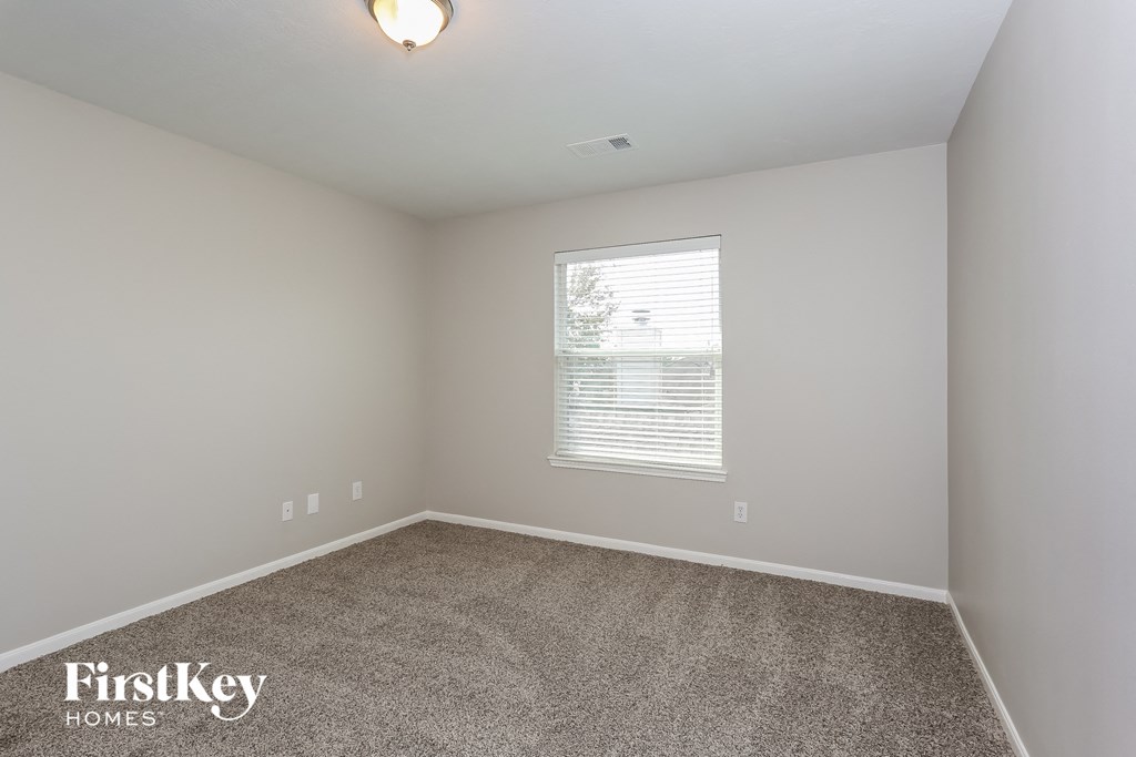 a bedroom with a carpeted floor and a window