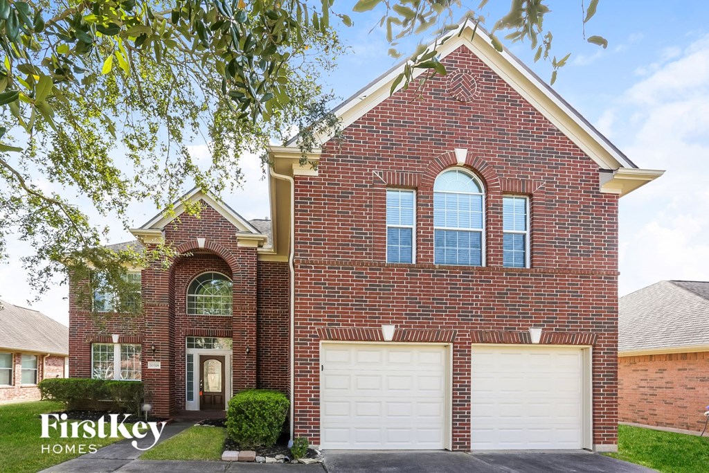 a red brick house with a white garage door