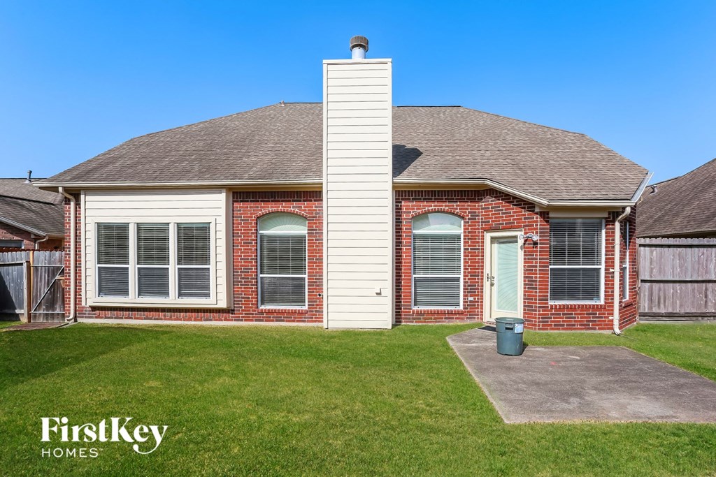 1920s era brick home with white siding and a green lawn