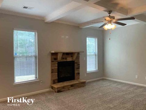 A living room with a fireplace and a ceiling fan.
