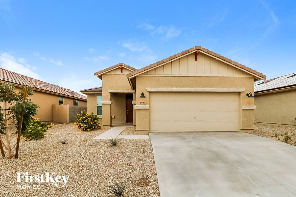a beige house with a garage and a driveway