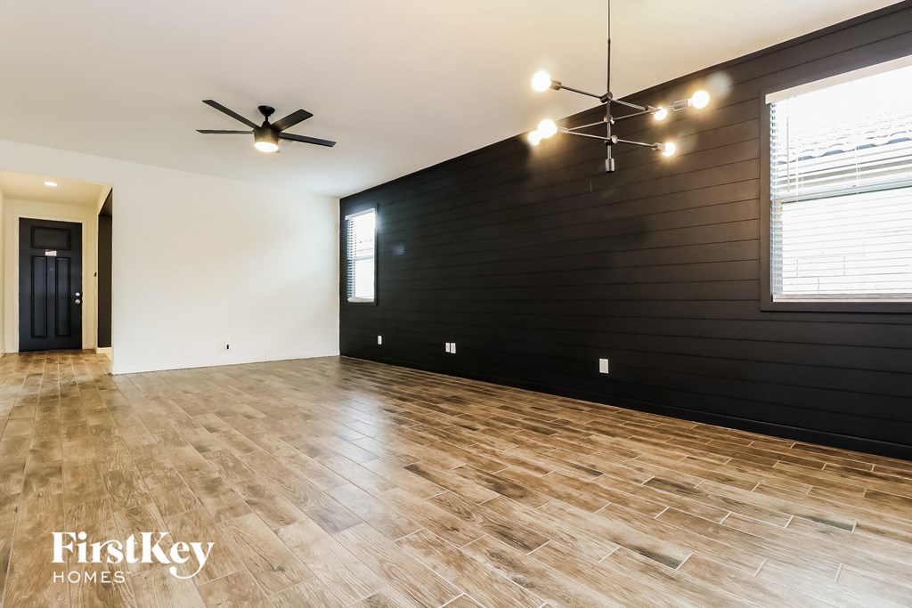 the living room with wood floors and a black accent wall