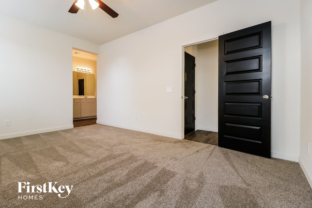 an empty living room with white walls and a black door