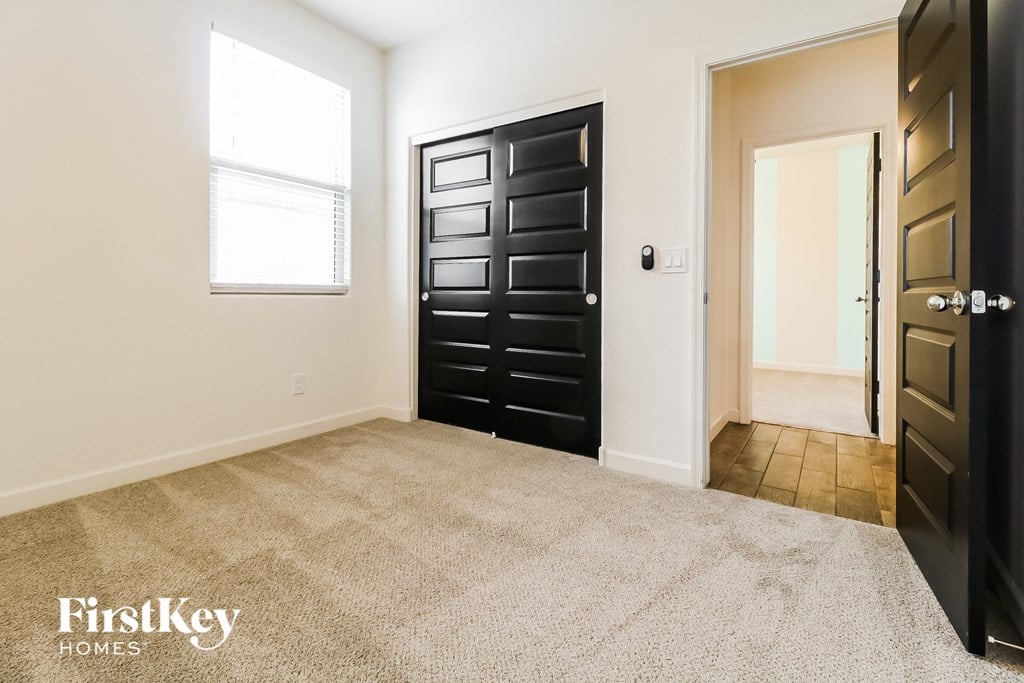 a room with a carpeted floor and a black door