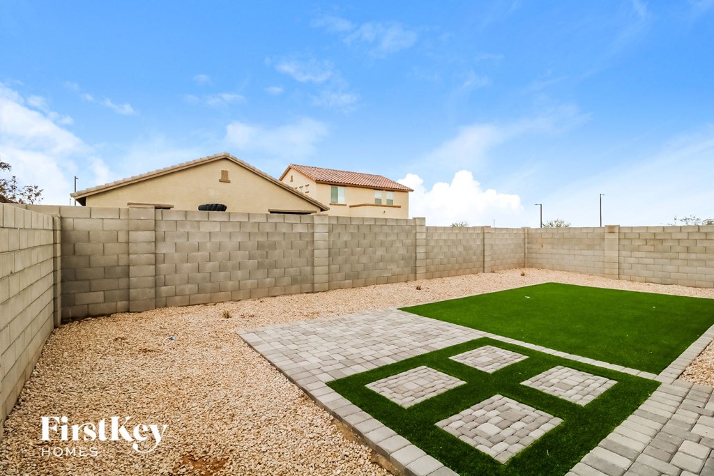 a backyard with a lawn and a house in the background