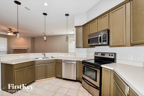 A kitchen with brown cabinets and a white counter top.