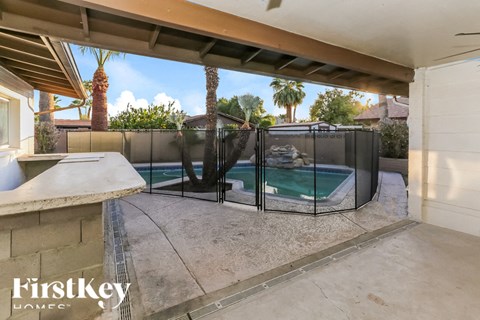 A pool enclosed by a black fence with a FirstKey Homes logo.
