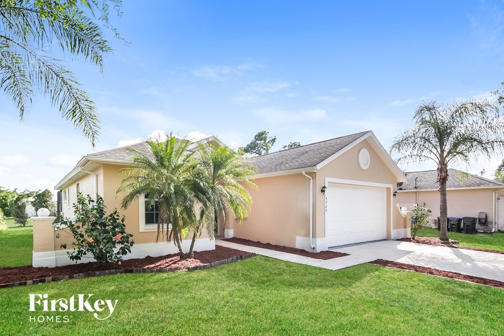 a beige house with palm trees in front of it