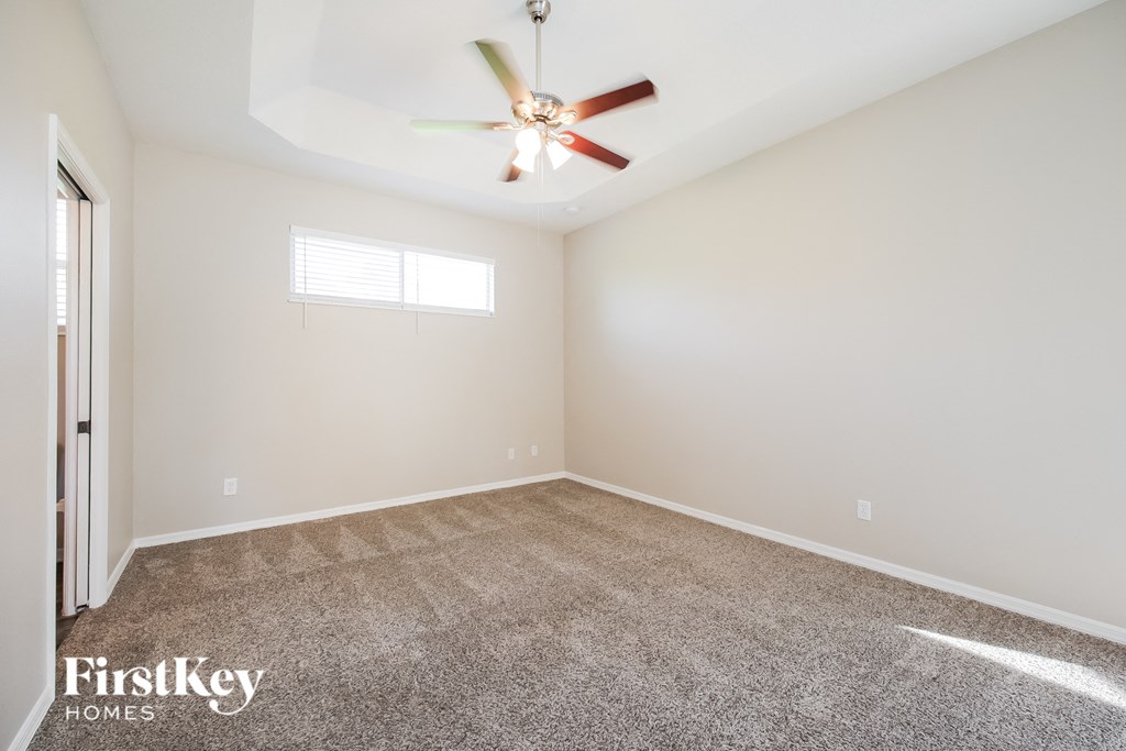 a room with carpet and a ceiling fan
