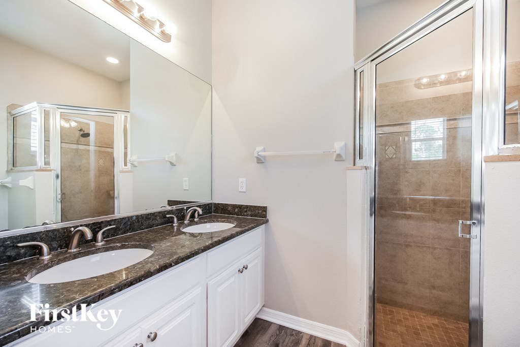 a bathroom with two sinks and a shower