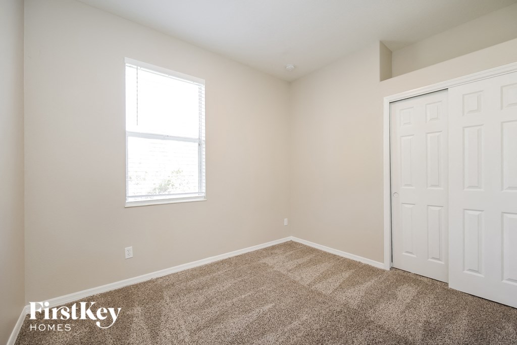 a bedroom with two closets and a window and carpeting